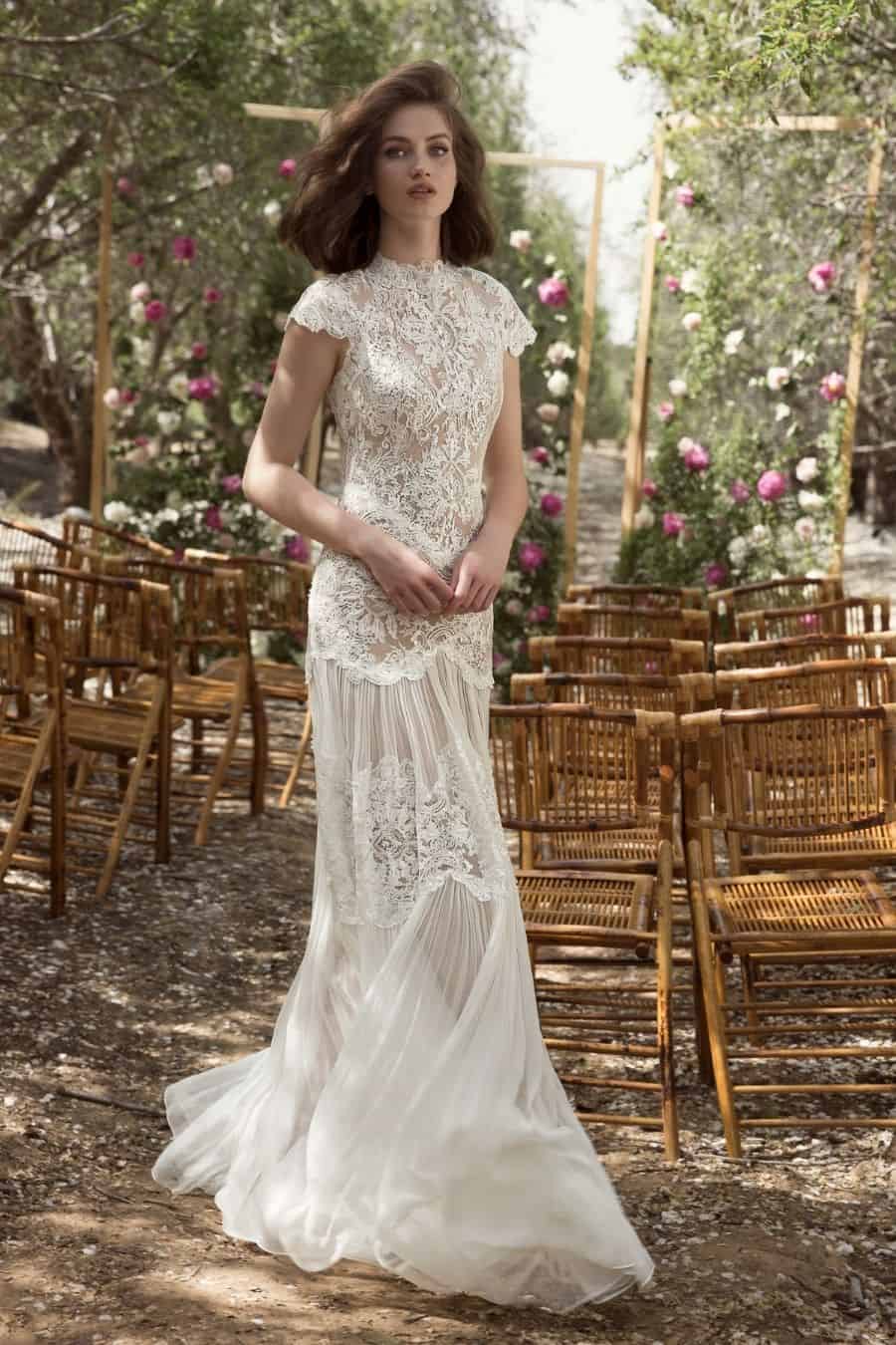 Bride walking in outdoor ceremony setting in lace wedding dress 