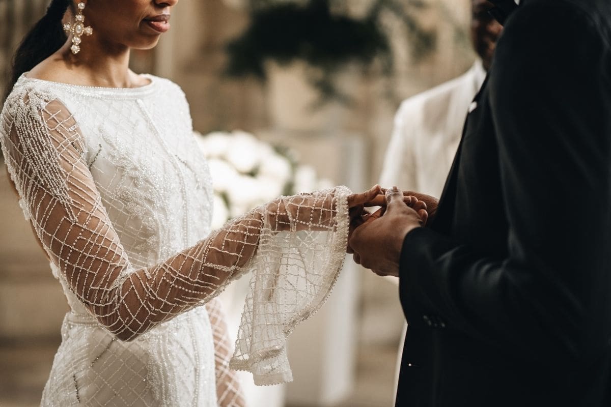 bride wearing long sleeve wedding dress and holding her hands together