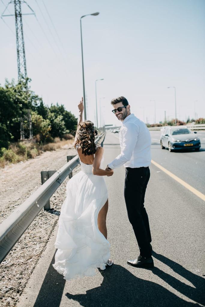 bruids en bruidegom rennend op snelweg in trouwjurk en pak