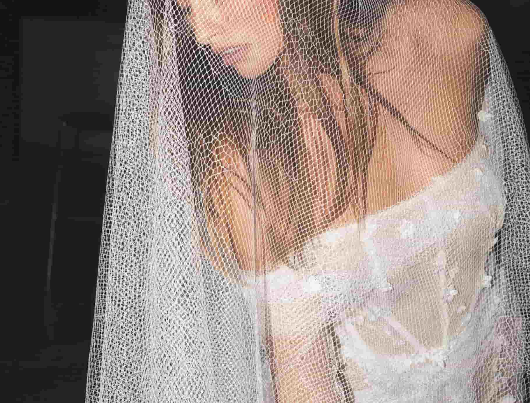 bruid in off-shoulder kanten trouwjurk met sluier