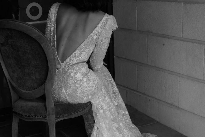 luxe couture kanten trouwjurk op bruid zittend op stoel